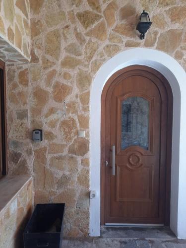 a wooden door of a stone building with a stone wall at Marathon VS LUXURY VILLA in Grammatiko