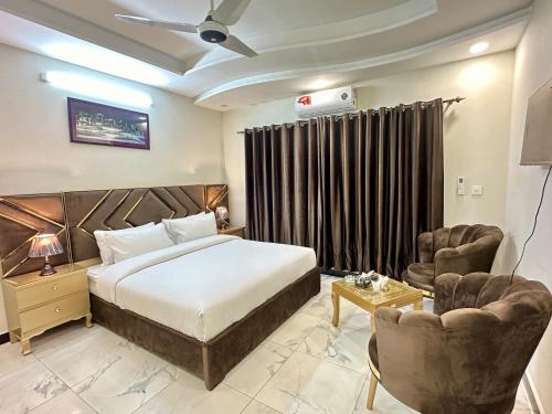 Habitación de hotel con 1 cama y 2 sillas en Dream Executive Guest House, en Islamabad
