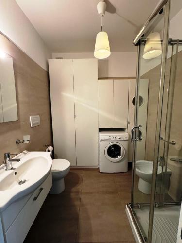 ein Badezimmer mit einem Waschbecken und einer Waschmaschine in der Unterkunft Elegante Appartamento Lungomare Kennedy in Otranto