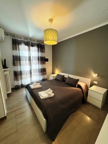 een slaapkamer met een groot bed en 2 handdoeken bij Elegante Appartamento Lungomare Kennedy in Otranto