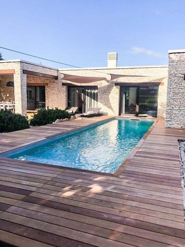 une piscine avec une terrasse en bois à côté d'une maison dans l'établissement Villa Bohème-chic, à Bonifacio
