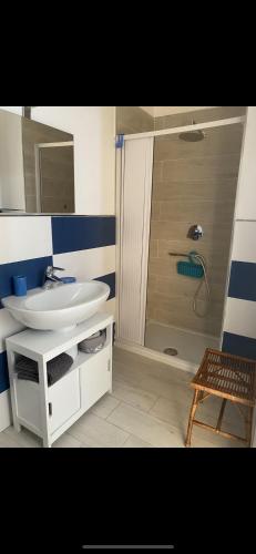 ein Badezimmer mit einem weißen Waschbecken und einer Dusche in der Unterkunft Le tre stelle in Castellabate