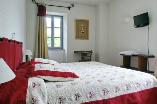 una camera con un letto con una coperta rossa e bianca di L'Auberge de Mens a Mens