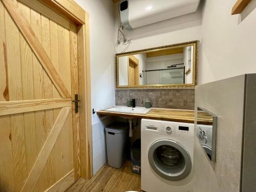 a laundry room with a sink and a washing machine at PIEPRZ i Wanilia - Kopalino dom z widokiem na las 3 pokoje taras parking WiFi - Pieprz in Kopalino