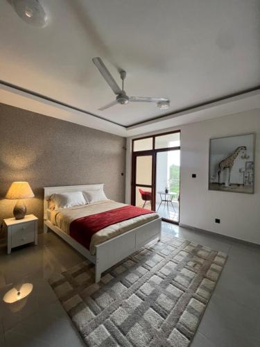 a bedroom with a bed with a red blanket at Penthouse Living in Mombasa