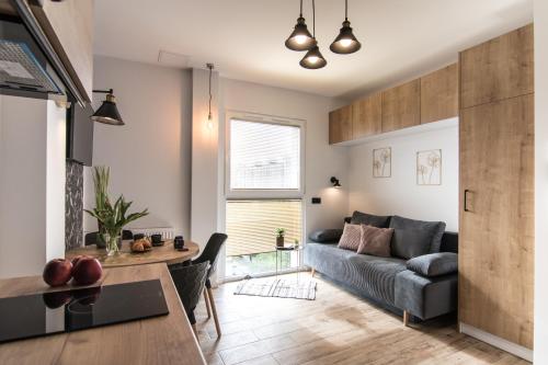 a living room with a couch and a table at Heron - 77 Apartments Wigury - Dostęp na KOD - Parking - Smaczna Kawa - Centrum - Blisko Piotrkowska - Galeria - Widok na miasto - Klimatyzacja - 7 piętro - FV in Łódź
