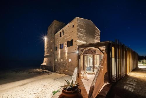 um edifício na praia à noite com um escorrega em Relais Torre Mozza - Dimora d' Epoca em Follonica