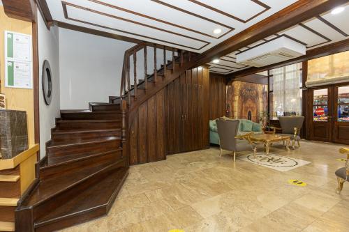 a lobby with a wooden staircase and a table at Bursa Grand Family HOTEL in Bursa