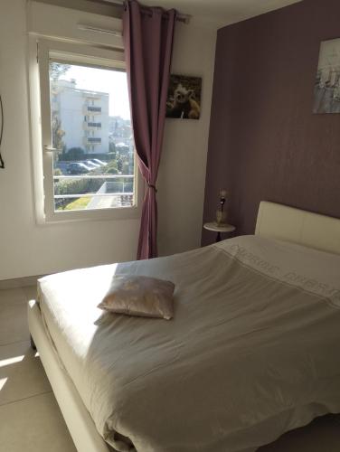 une chambre avec un grand lit avec une fenêtre dans l'établissement 2P Piscine proche mer, à Fréjus
