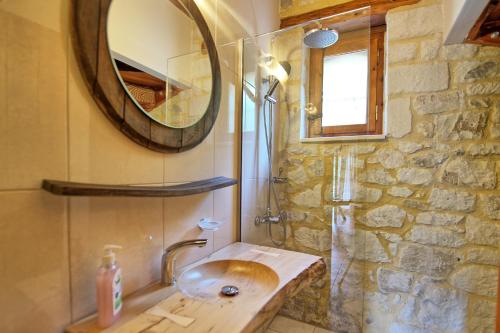 uma casa de banho com um lavatório e um espelho em Villa Nipos by PosarelliVillas em Vryses