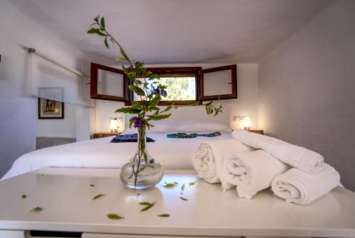 ein Schlafzimmer mit einem Bett und einer Vase mit Blumen auf dem Tisch in der Unterkunft villa barbarosa in Es Arenals