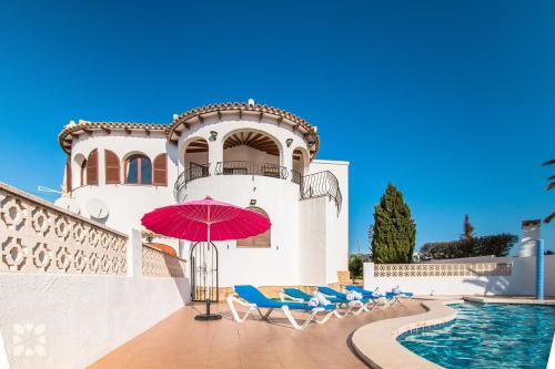 a pool with chairs and a red umbrella next to a building at Villa Rachelle by Abahana Villas in Calpe