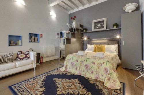 フィレンツェにあるSanto Spirito Studio Flatのベッドルーム(ベッド1台、ソファ付)