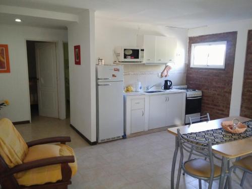een keuken met een witte koelkast en een tafel bij Departamentos Nqn Equipados in Neuquén