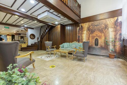 a living room with a table and chairs and a fireplace at Bursa Grand Family HOTEL in Bursa