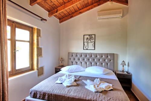 a bedroom with a bed with towels on it at Villa Romantic Sevi by PosarelliVillas in Káto Vení
