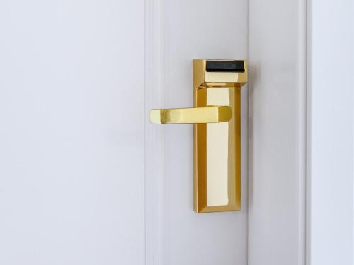 a gold door handle on a white door at Hotel Münkel in Hannover