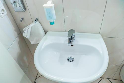 a bathroom with a white sink and a bottle of soap at Hotel Münkel in Hannover