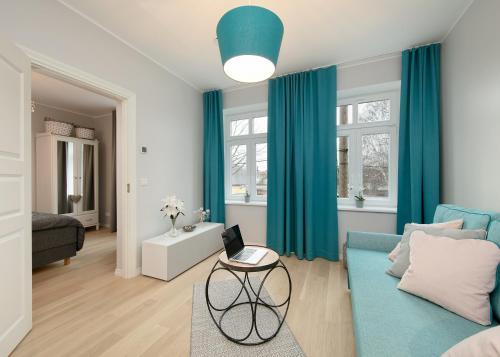 een woonkamer met blauwe gordijnen en een blauwe bank bij Kalamehe Apartment 4 near City center in Pärnu