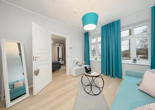 sala de estar con cortinas azules y sofá azul en Kalamehe Apartment 4 near City center, en Pärnu