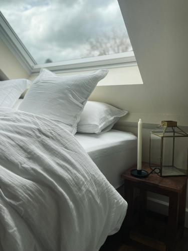 a bedroom with a bed with white sheets and a window at Edda Country House - Val de Loire in Onzain