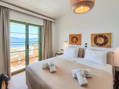 - une chambre avec un grand lit et des serviettes dans l'établissement Hotel Dafni, à Megali Ammos