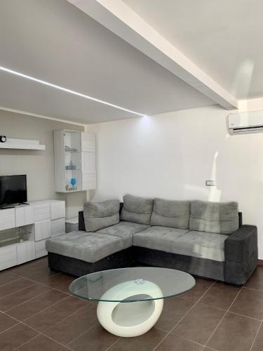 uma sala de estar com um sofá e uma mesa de vidro em Holiday House em Palermo