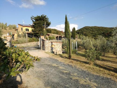 a house with a fence and a dirt road at Cintoia, Tuscany Beautiful villa with private pool in Santa Luce
