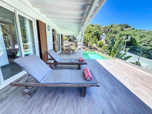 un porche con una silla y una piscina en Villa Romane private pool breathtaking sea view, en Anse Marcel 