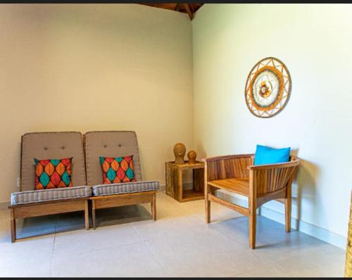 a living room with two benches and a chair at Angá Beach Hotel in São Miguel dos Milagres