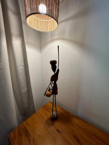 a doll sitting on a table under a chandelier at Angá Beach Hotel in São Miguel dos Milagres