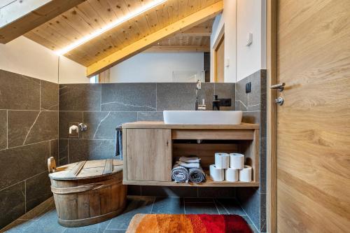 a bathroom with a sink and a toilet and a mirror at Krämerhof Apt Villnösser Geisler in Rodengo