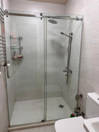 y baño con ducha y puerta de cristal. en batumi apartament en Batumi