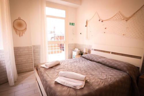 una camera da letto con un letto e due asciugamani di Holidayhouse Ostia - Libeccio a Lido di Ostia