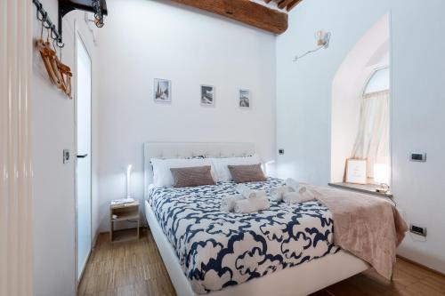 Dormitorio blanco con cama con edredón blanco y negro en Pisa Central Lovely Studio near Palazzo Blu, en Pisa