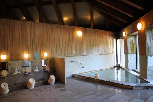 een grote badkamer met een bad en 2 toiletten bij TOYOTA Shirakawa-Go Eco-Institute in Shirakawa