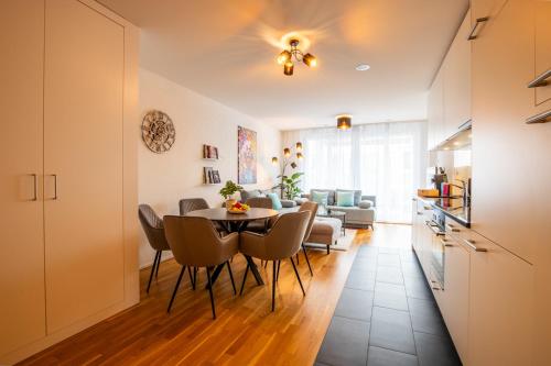 a dining room and living room with a table and chairs at Special EiNSTEiN I Apartment Basel, Messe Kleinbasel 10-STAR in Basel
