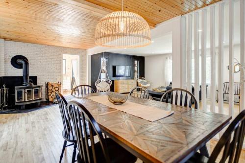 a dining room with a large wooden table and chairs at La Casa del Plage - Spa privé et Hamak in Sainte-Lucie-de-Doncaster