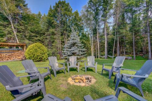 a group of lawn chairs around a fire pit at La Casa del Plage - Spa privé et Hamak in Sainte-Lucie-de-Doncaster