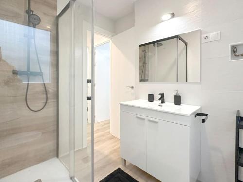 uma casa de banho com um lavatório branco e um chuveiro em Apartamento reformado en Santoña em Santoña