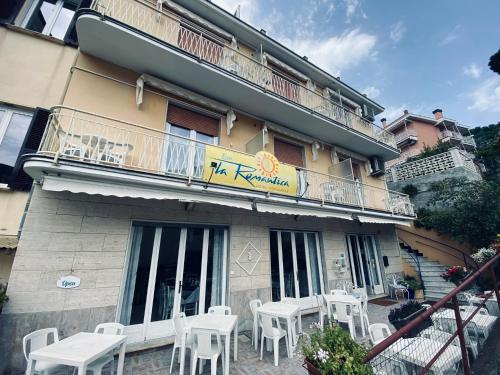 a building with white tables and chairs in front of it at Hotel Eva La Romantica in Moneglia