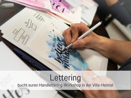 a person holding a pen and writing on a book at Villa Heimat am Nationalpark in Allenbach
