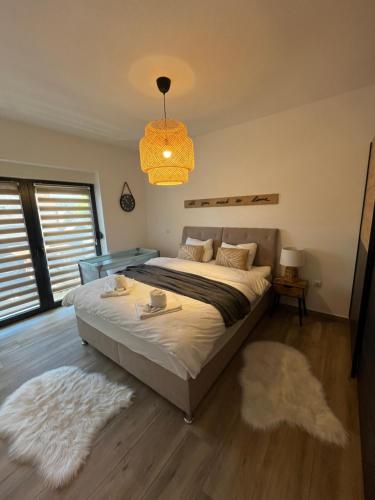 ein Schlafzimmer mit einem großen Bett und einem Kronleuchter in der Unterkunft Apartman Sandra in Nova Gradiška