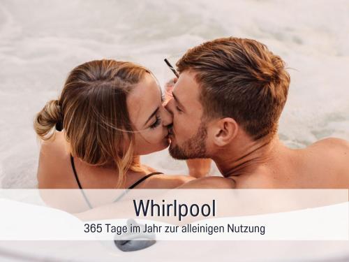 a man and a woman kissing in the water at Villa Heimat am Nationalpark in Allenbach