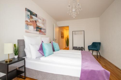 a bedroom with a large white bed and a chandelier at Special EiNSTEiN I Apartment Basel, Messe Kleinbasel 10-STAR in Basel
