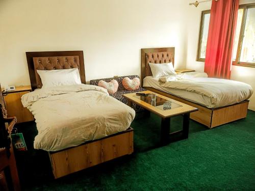 um quarto com 2 camas, uma mesa de centro e um sofá em Lashari Resort em Skardu