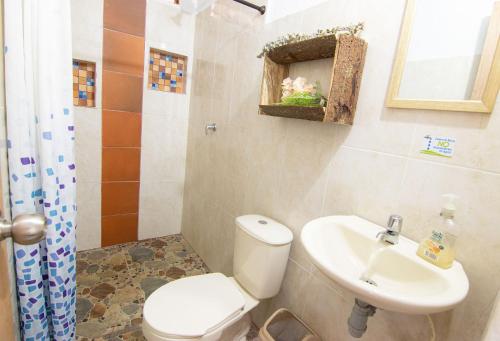 a bathroom with a white toilet and a sink at Casa Viva Alojamiento Rural in Jardin