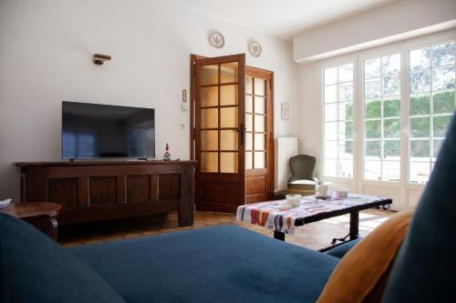 - un salon avec une télévision et une table dans l'établissement Villa Topaze La Baule les Pins, à La Baule