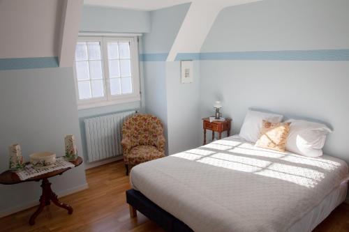 a bedroom with a bed and a chair and a window at Villa Topaze La Baule les Pins in La Baule