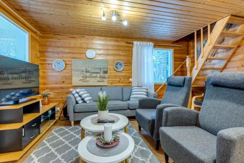 a living room with couches and a staircase at Mehtämökki in Kalajoki